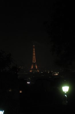 a la distancia la torre Eiffel iluminada